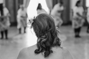 Back of bride's head watching the traditional dances being performed on her wedding day.