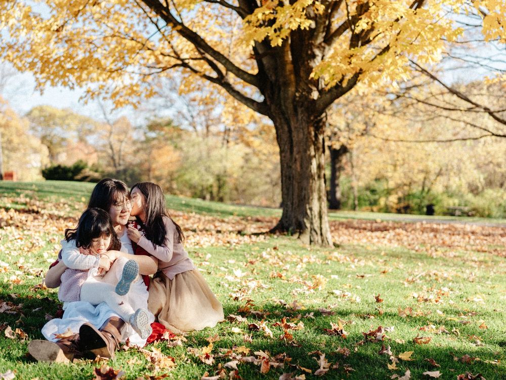 A family enjoys a picturesque autumn day at the Larz Anderson Park, Brookline, MA.