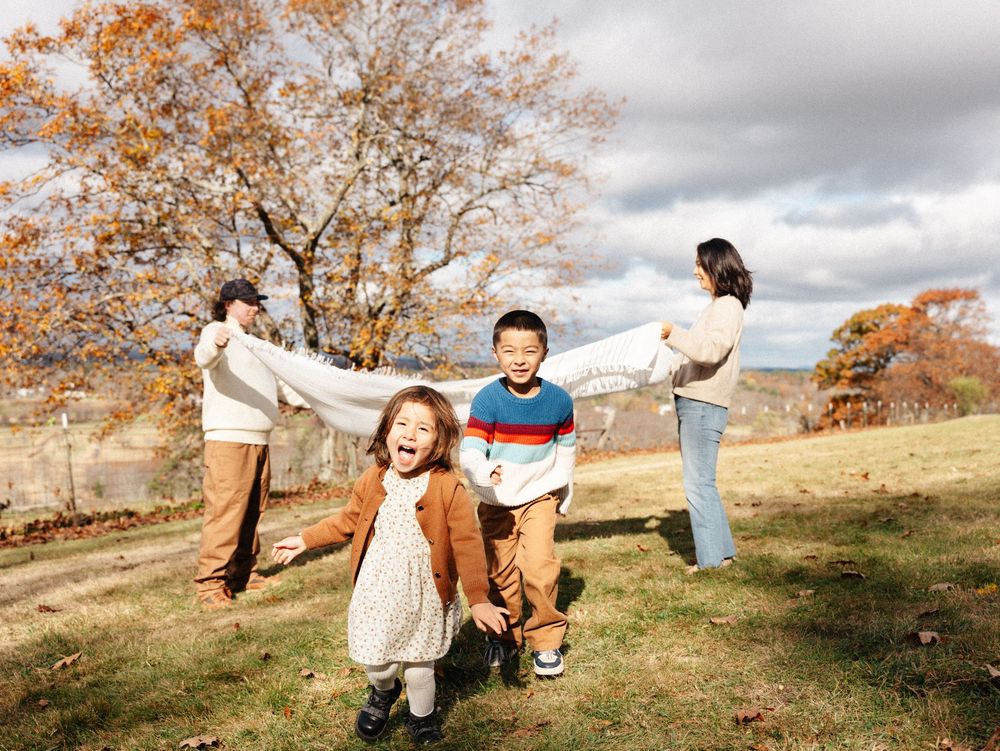 A playful series of photos showing people enjoying a fall day on a grassy hillside with golden autumn trees in the background.