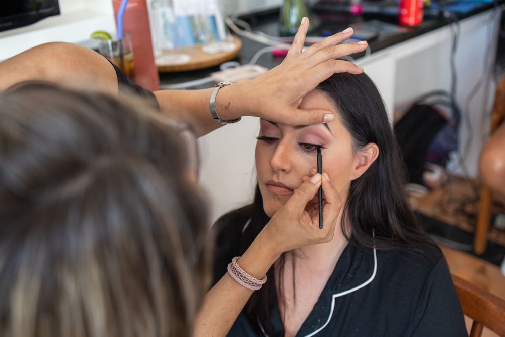 Professional makeup application in progress showing eye makeup being done.
