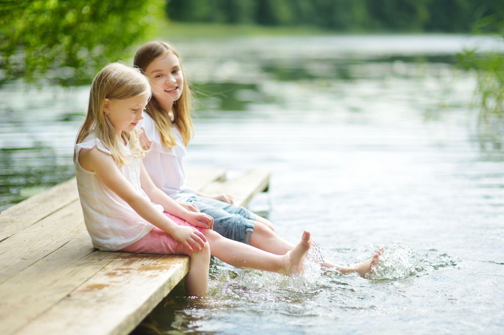 girls splash their legs in the water not a care in the world since their parents are covered through Smithtree insurance
