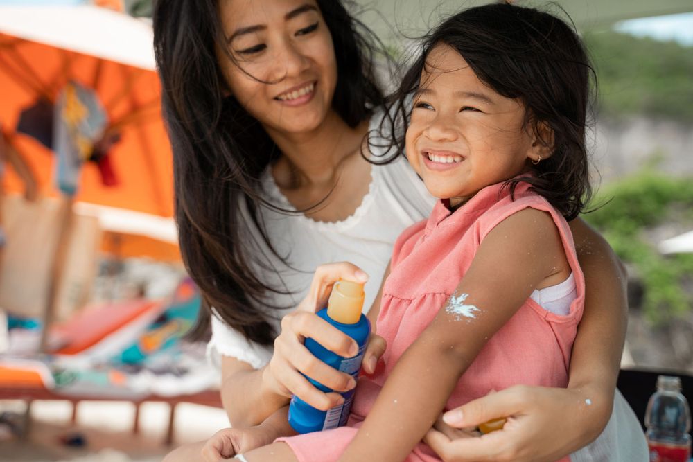 mom adds sunscreen to her daughters skin to protect her knowing her healthcare is covered by Smithtree insurance