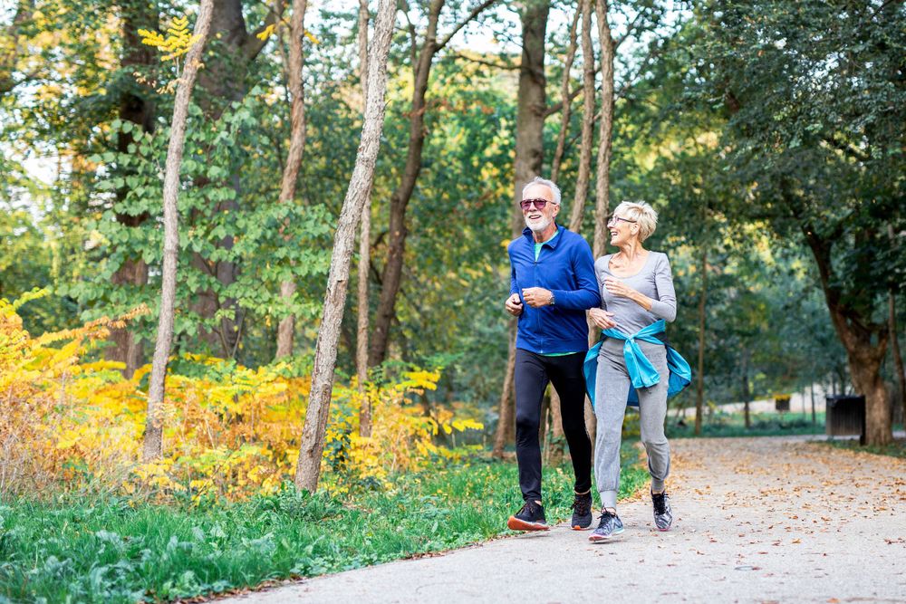 couple in their 60's jogs on a path together happy to have great coverage with Smithtree Insurance