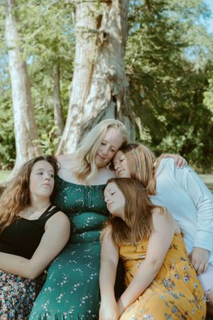 A mother tenderly embracing her three daughters during an outdoor family portrait session in Central Texas.