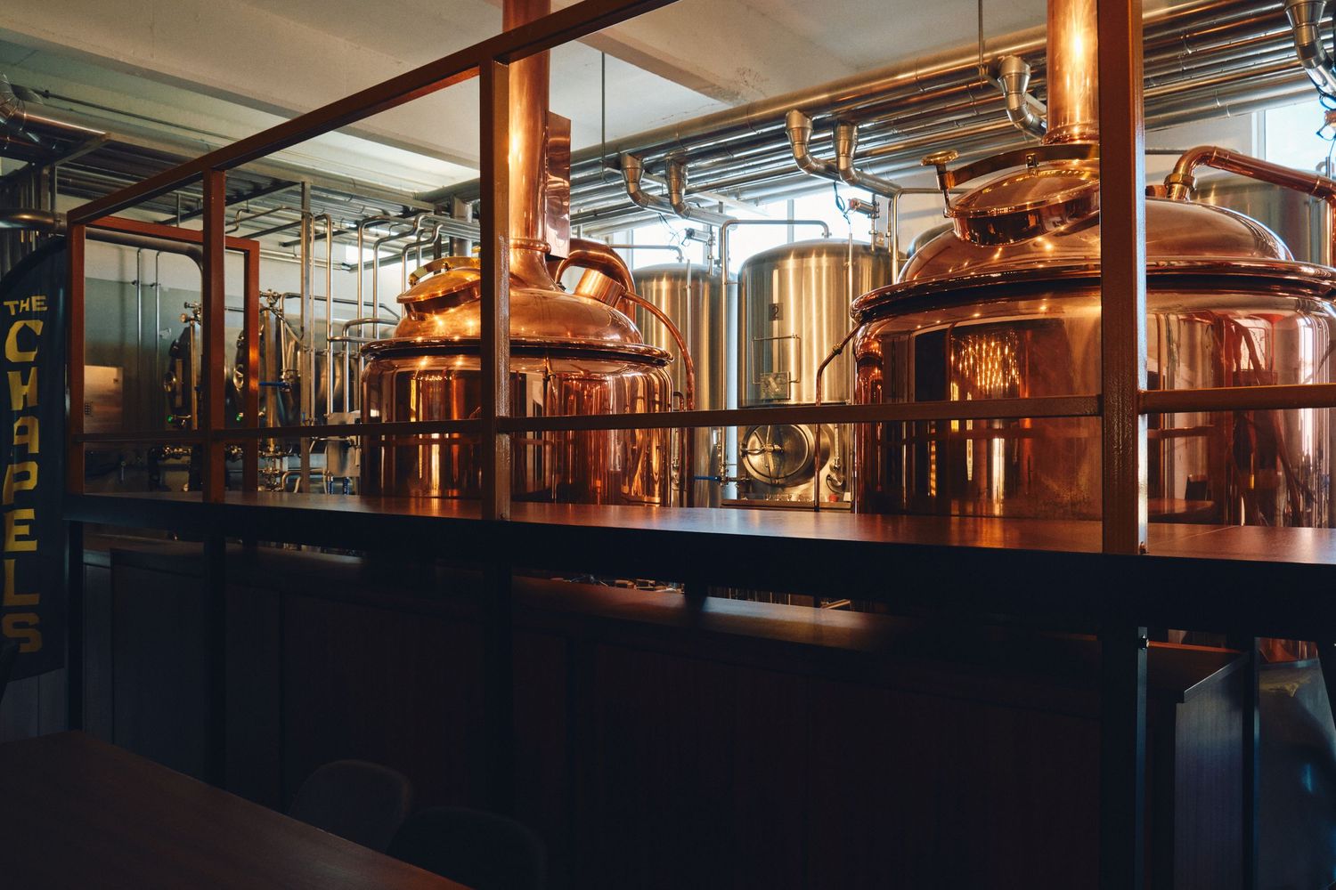 Large copper brewing tanks in an industrial brewery setting.