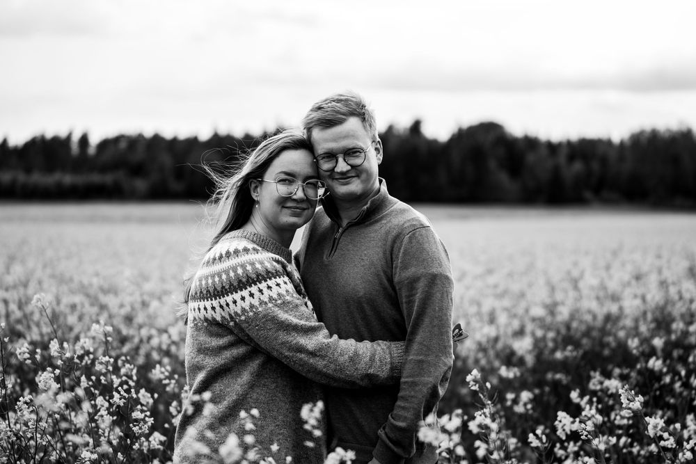 A romantic black and white series of photos showing a couple embracing in a blooming flower field.