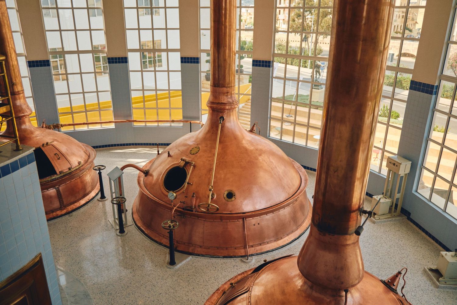Large copper brewing tanks in an industrial brewery facility.