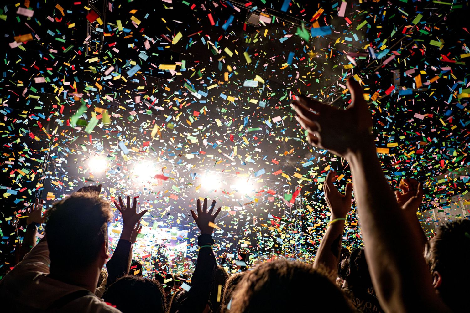 Colorful confetti falls from above during an exciting concert celebration scene.