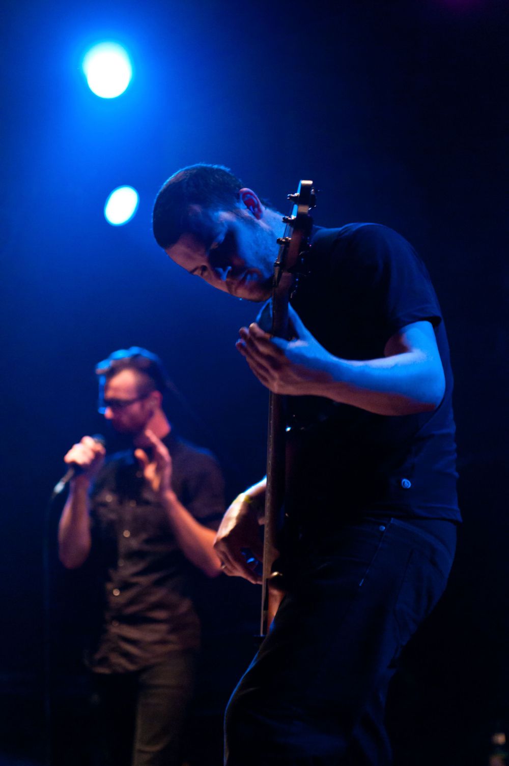 Guitarist and singer of Karnivool playing in Poughkeepsie, NY lit by blue stage lights