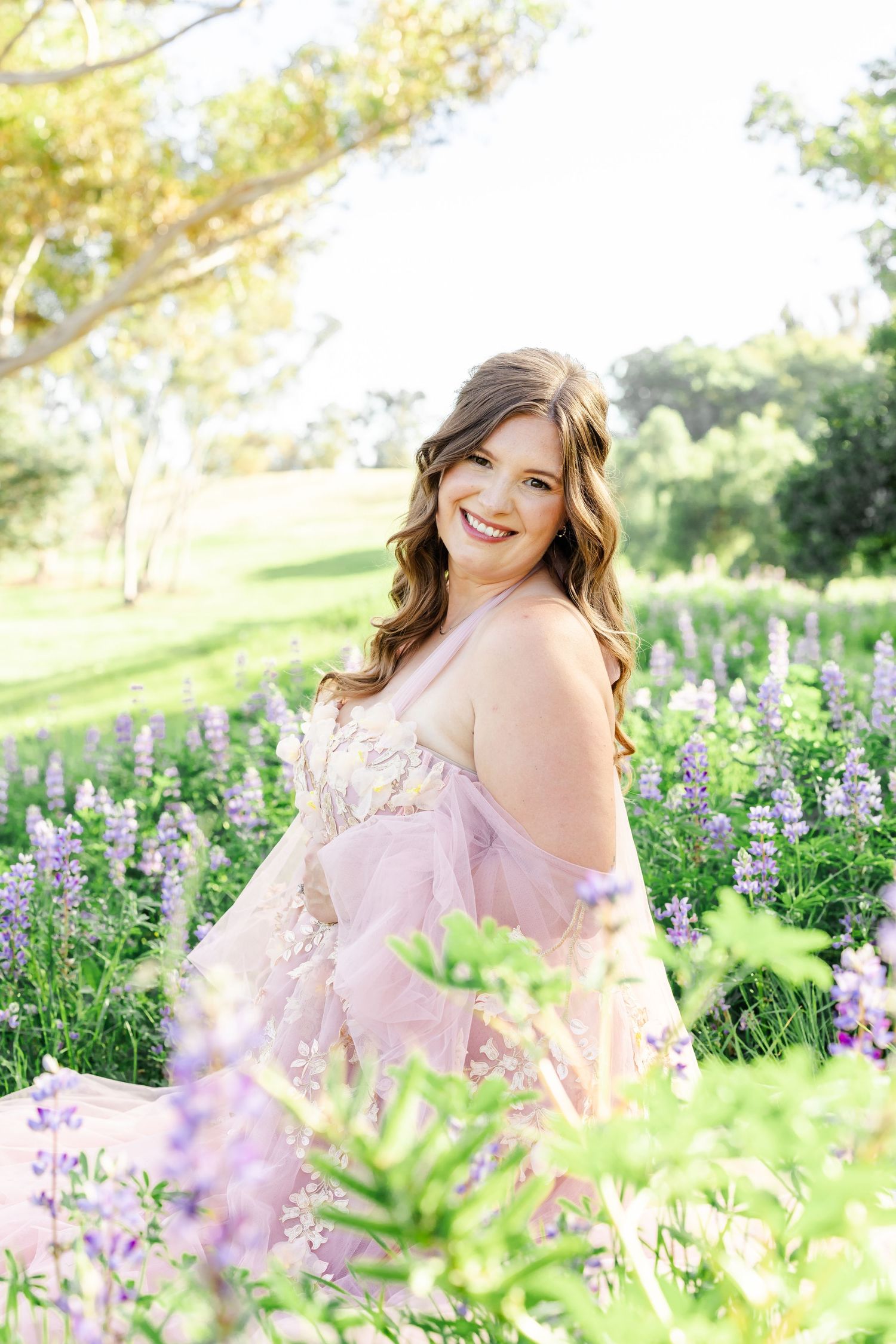 Maternity photoshoot under ornate stone columns features flowing light blue dress and dramatic poses.