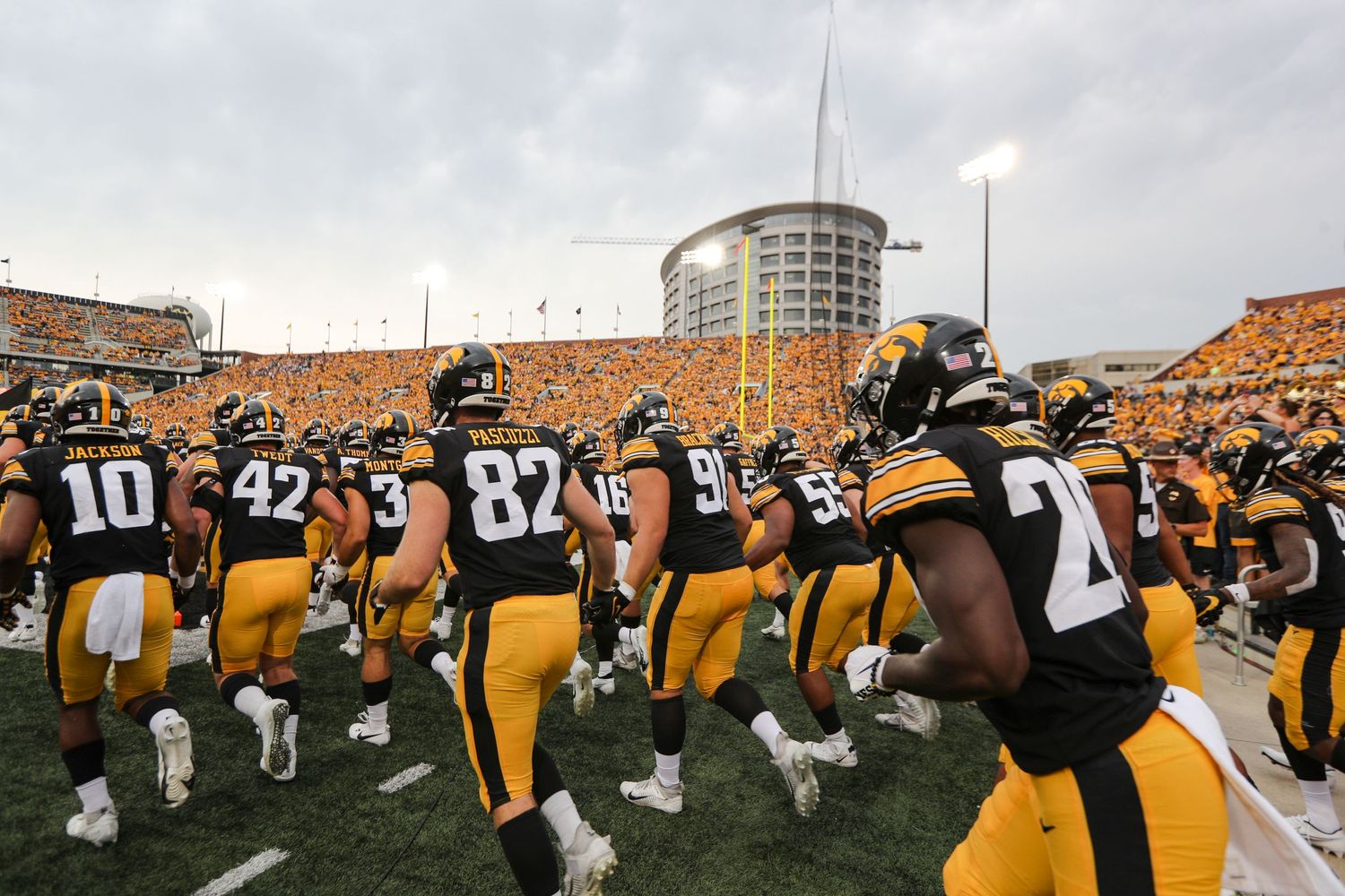 Iowa Hawkeyes football team huddles together on the field before a game.