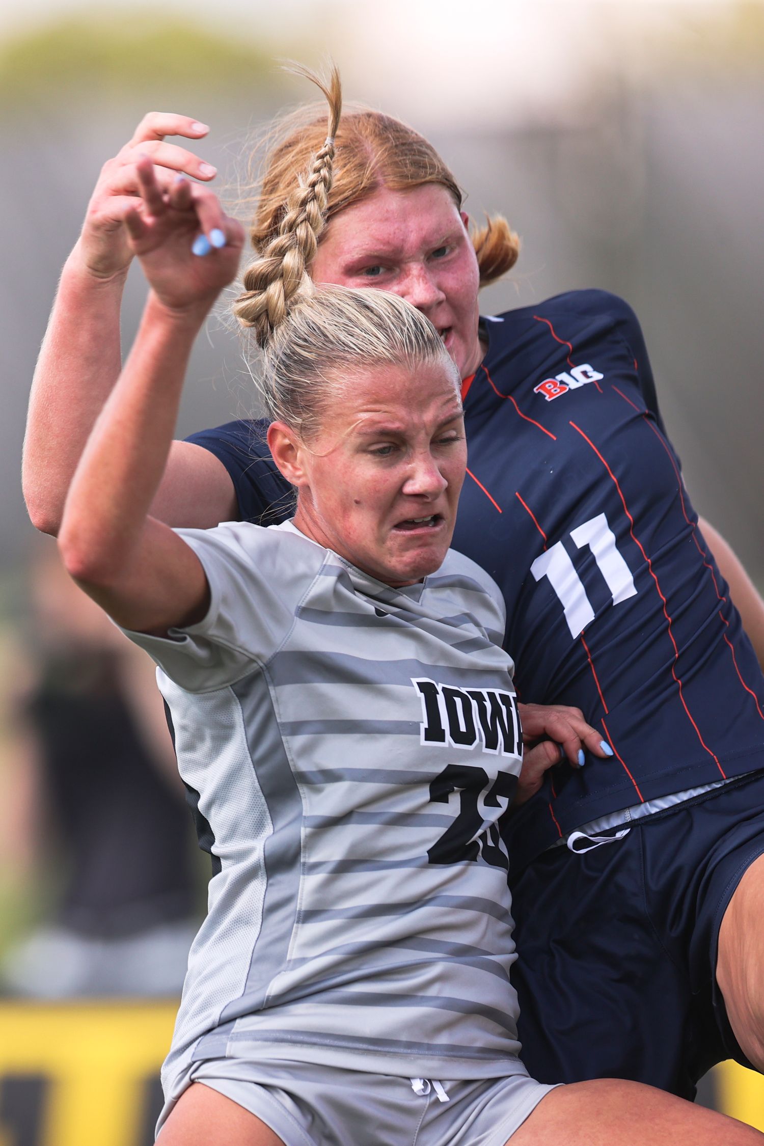 Two soccer players battle for possession during an intense match.