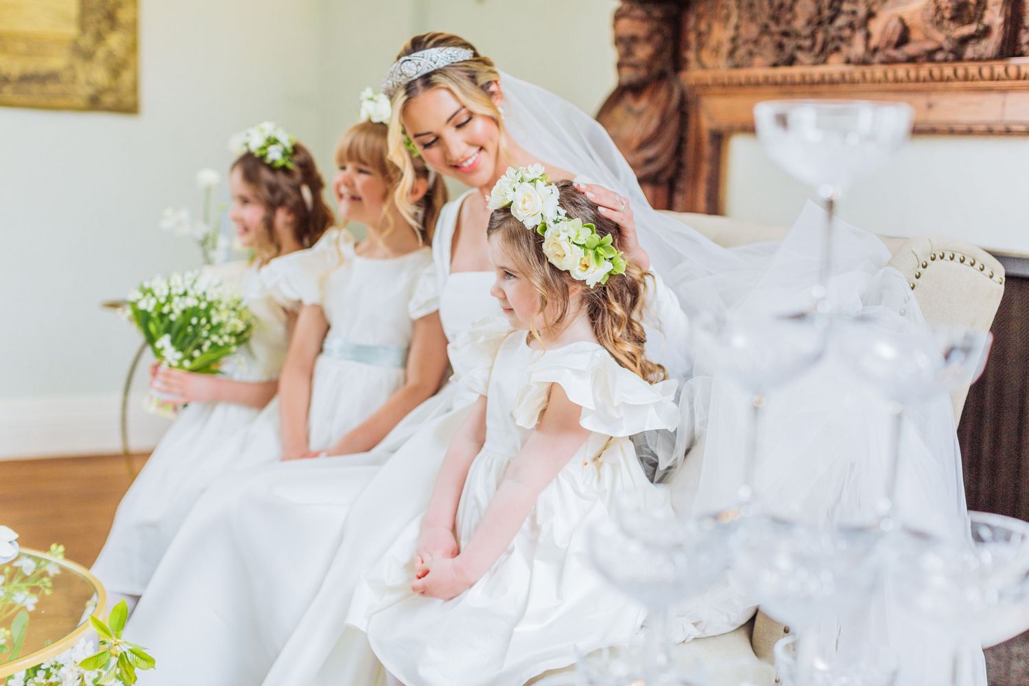 Hayley Elizabeth luxury wedding photographer Cornwell manor the cotswolds photography bride and flower girls sat togethe