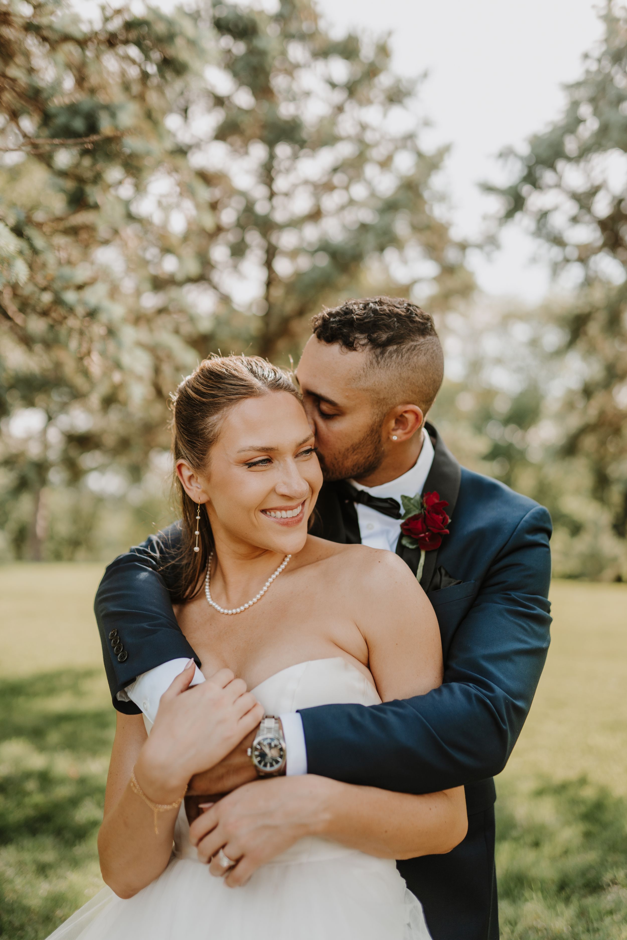 Intimate moment between newlyweds during outdoor wedding portraits.