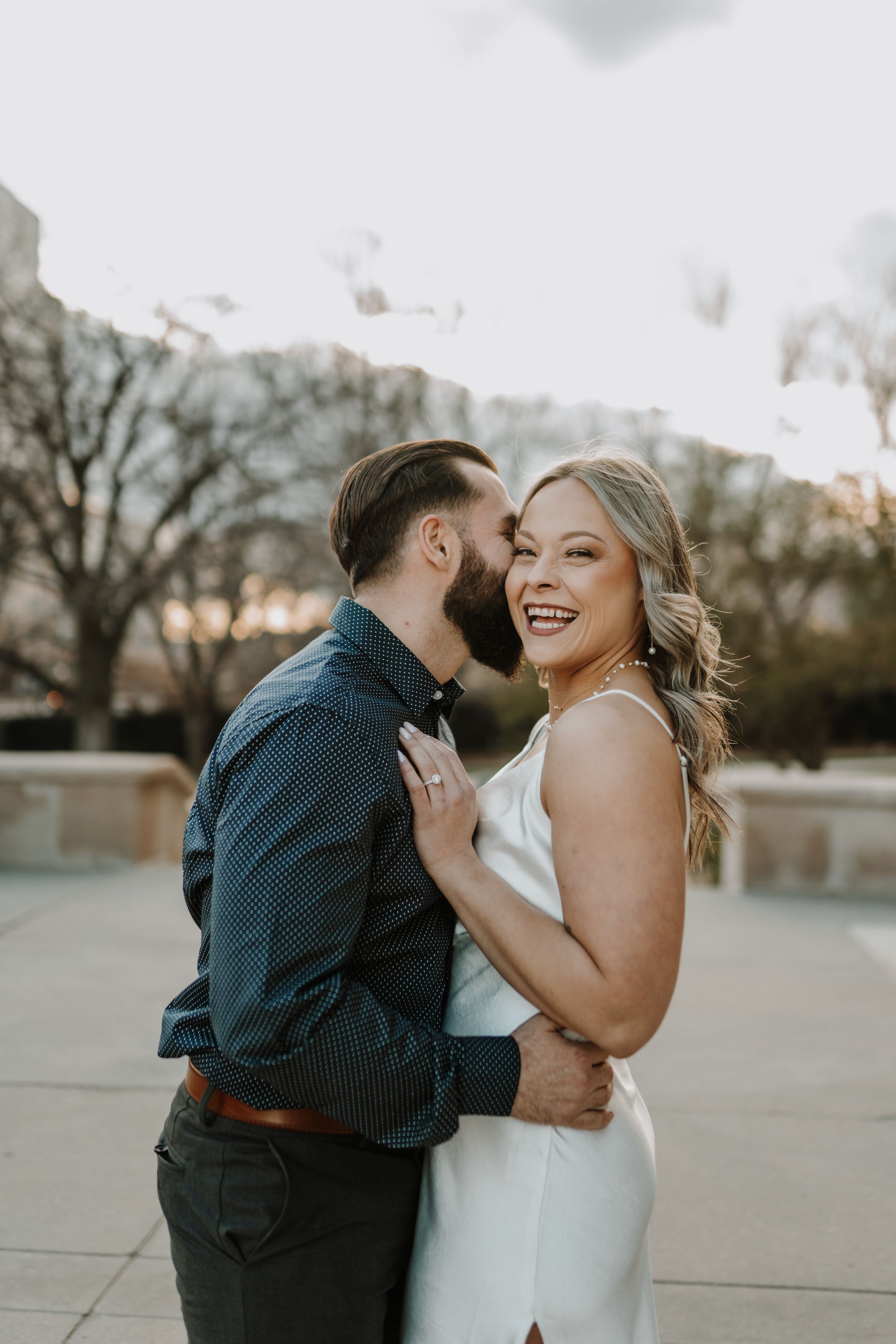 A joyful candid moment between the couple sharing laughs and embraces during their wedding photoshoot.
