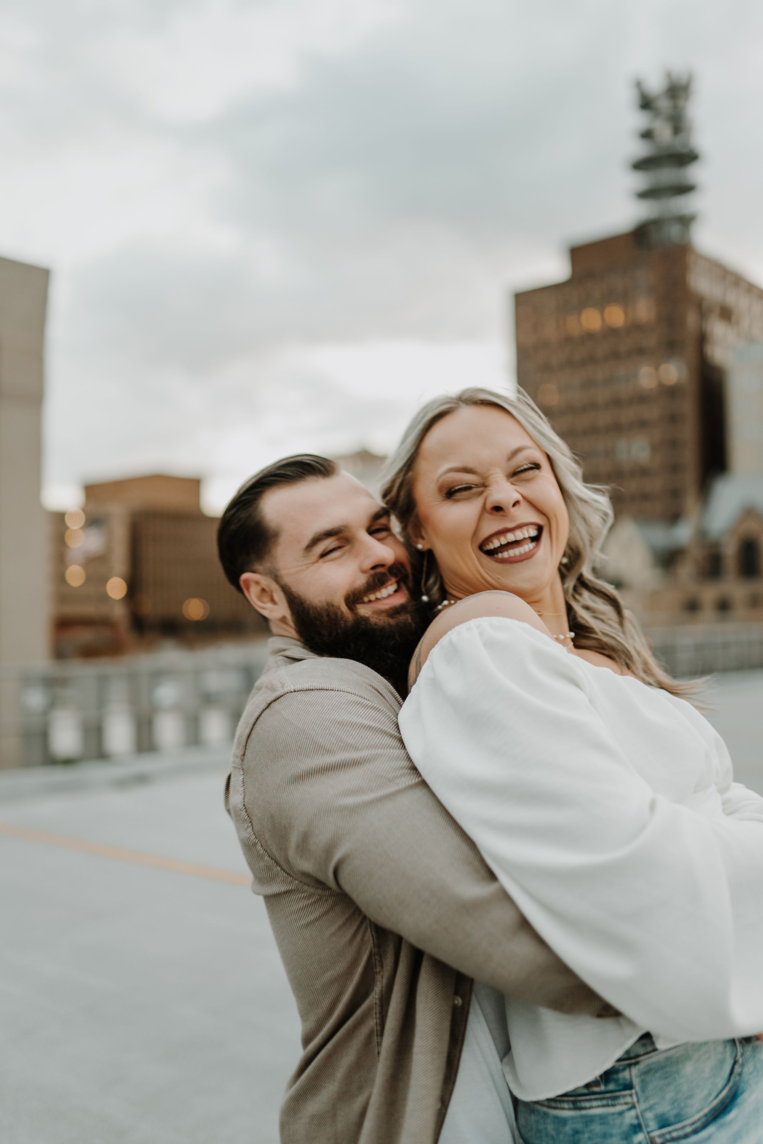 Candid photos capturing playful and joyful moments between a couple against an urban backdrop.