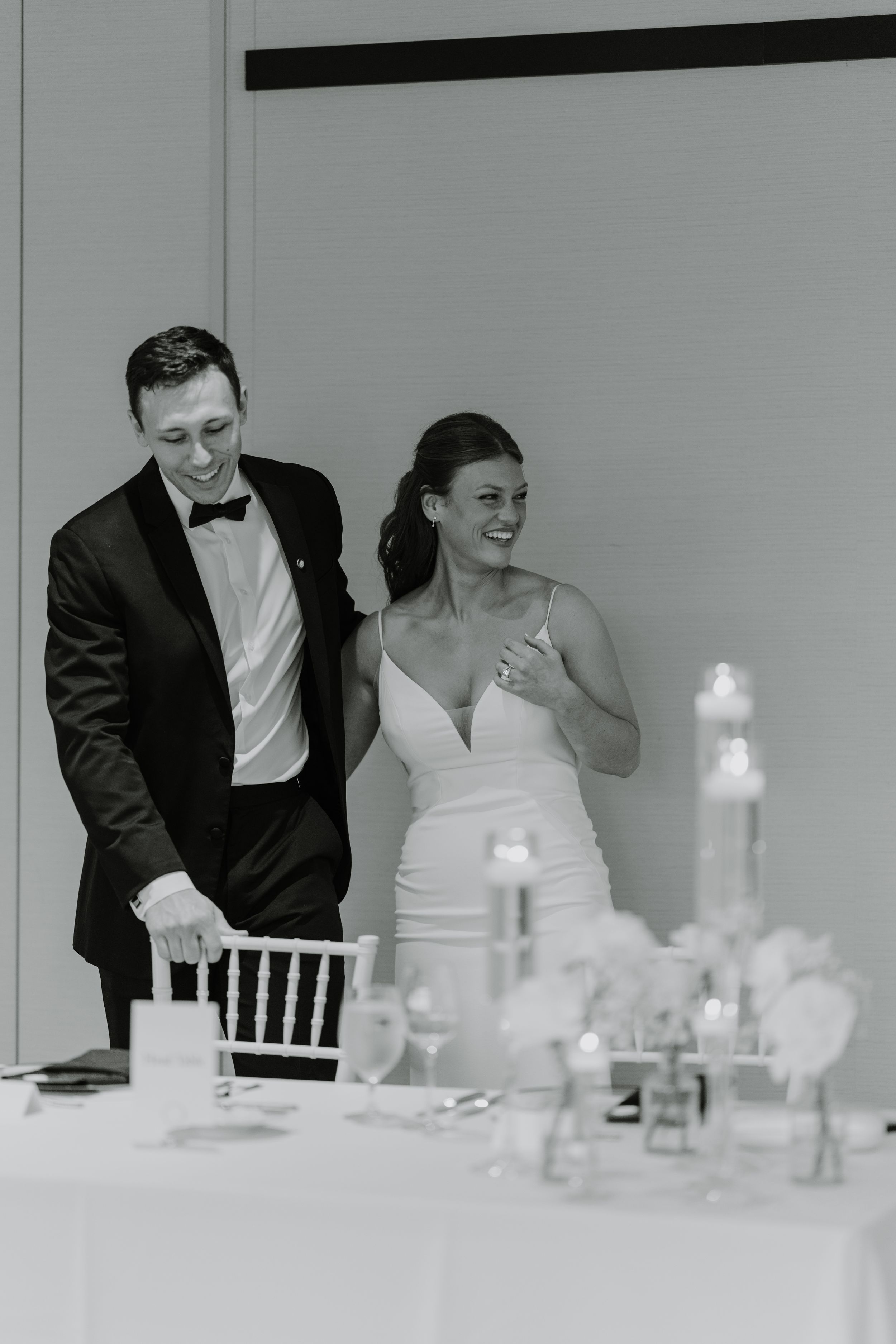Candid reception moments between wedding couple at an elegant dining table.
