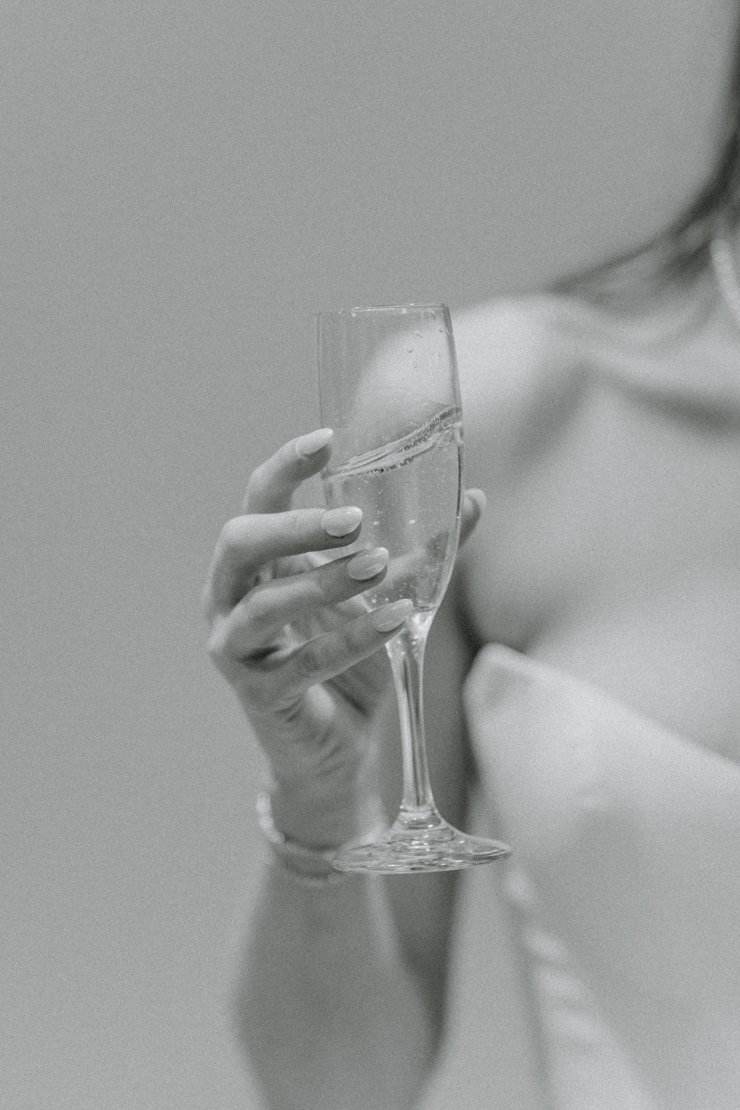 Black and white image of a hand holding a champagne flute.