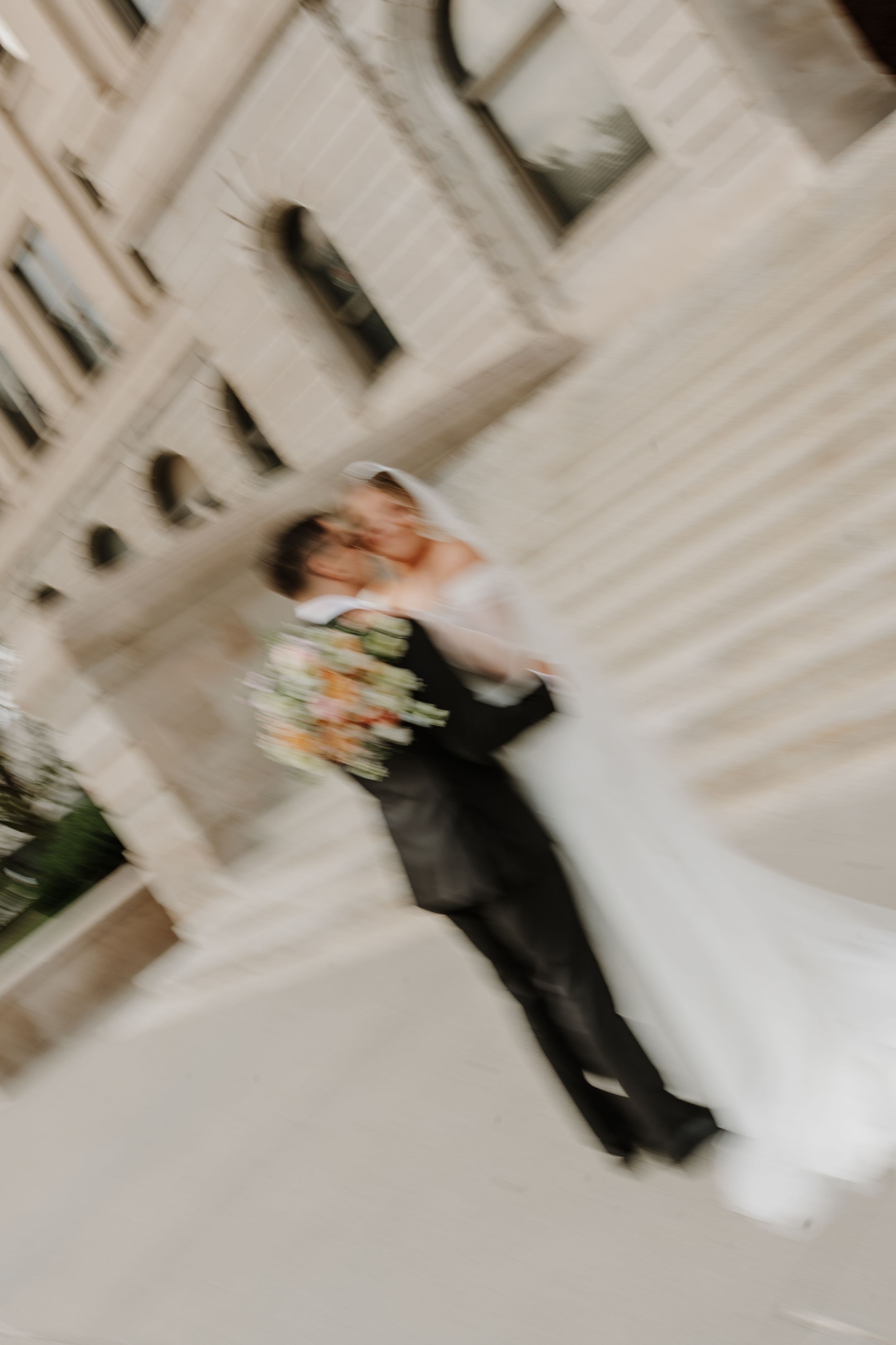 An aerial view showing a playful bridal party lying down on the ground in a geometric pattern at a wedding.