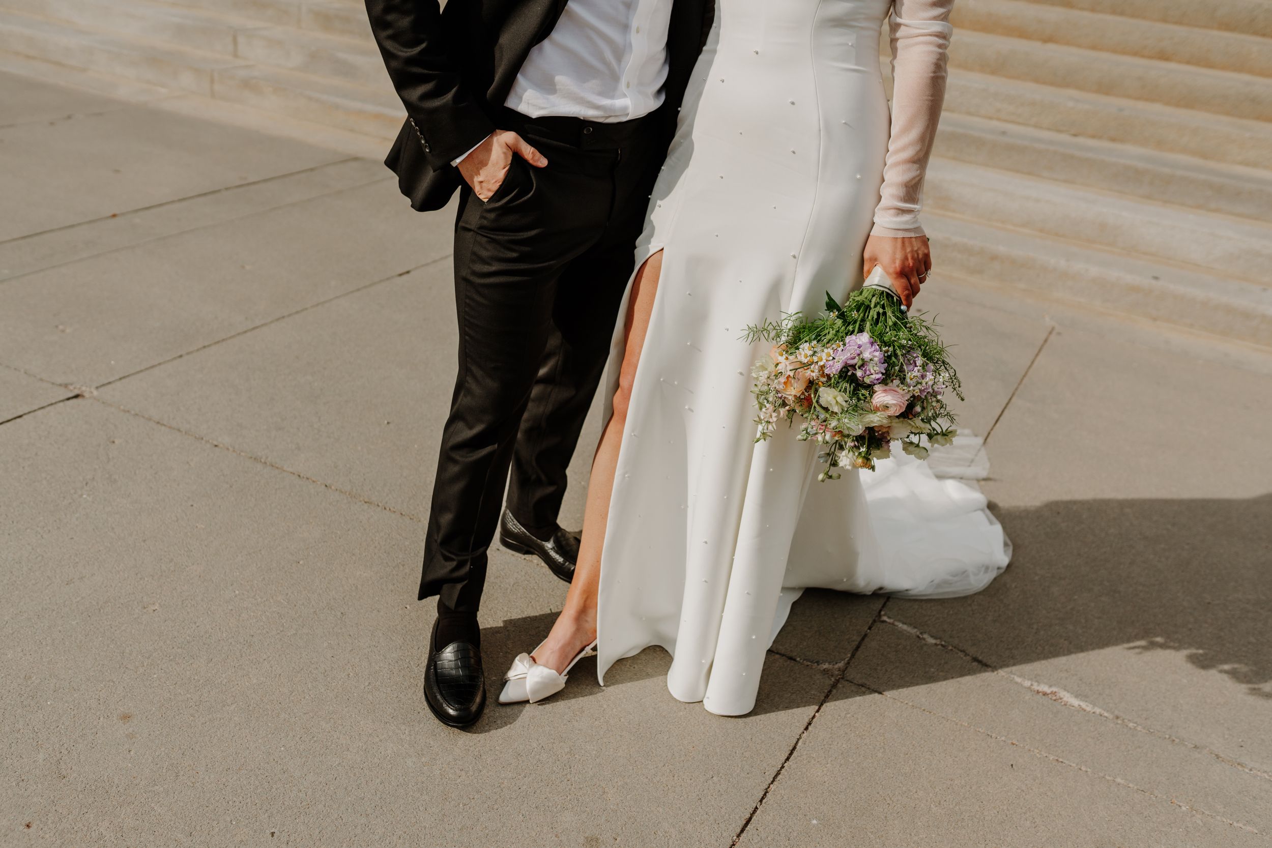 Low-angle view of wedding party members arranged in a creative ground formation.