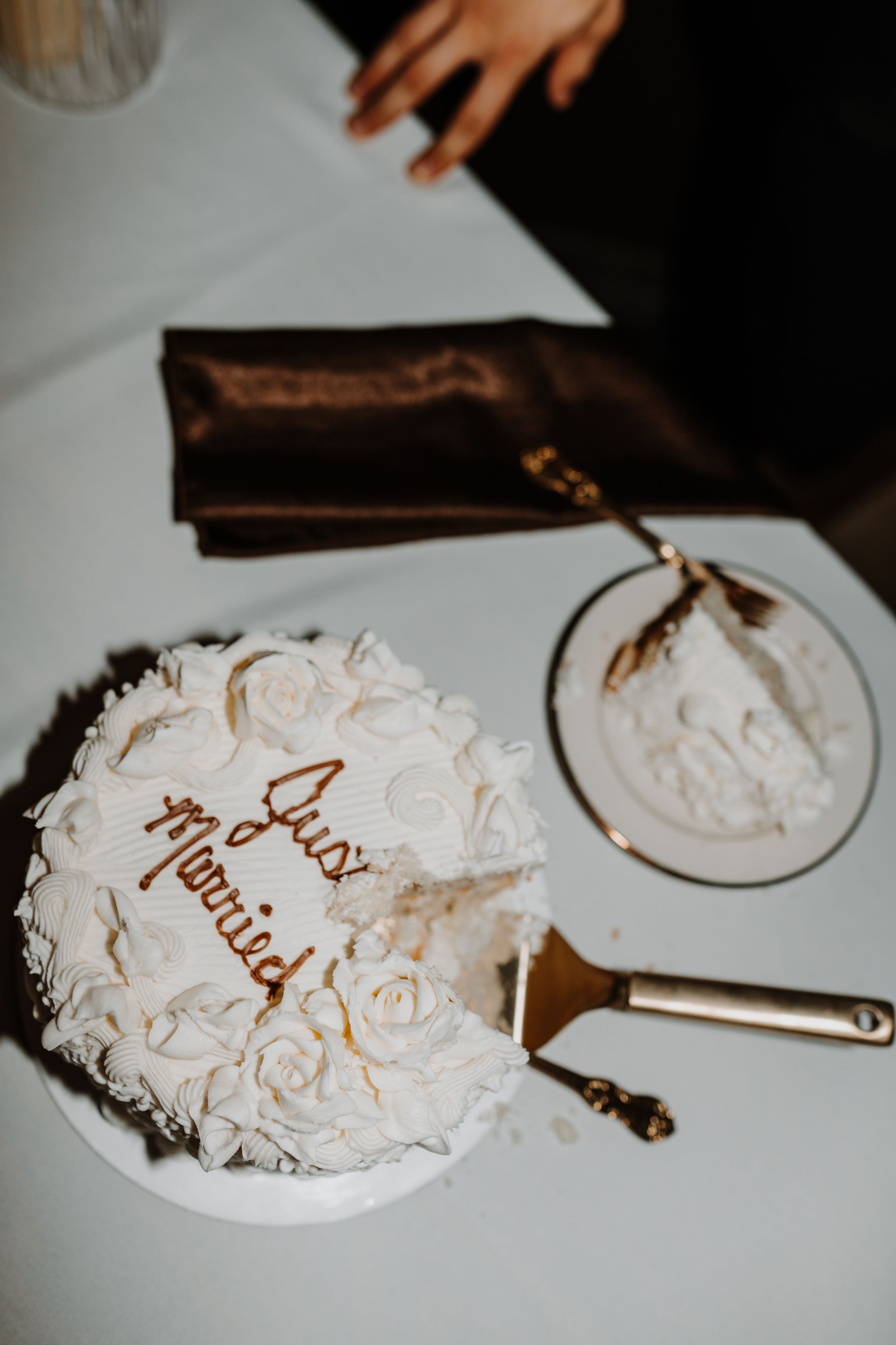 Overhead view of an elegant white wedding cake with gold script writing.