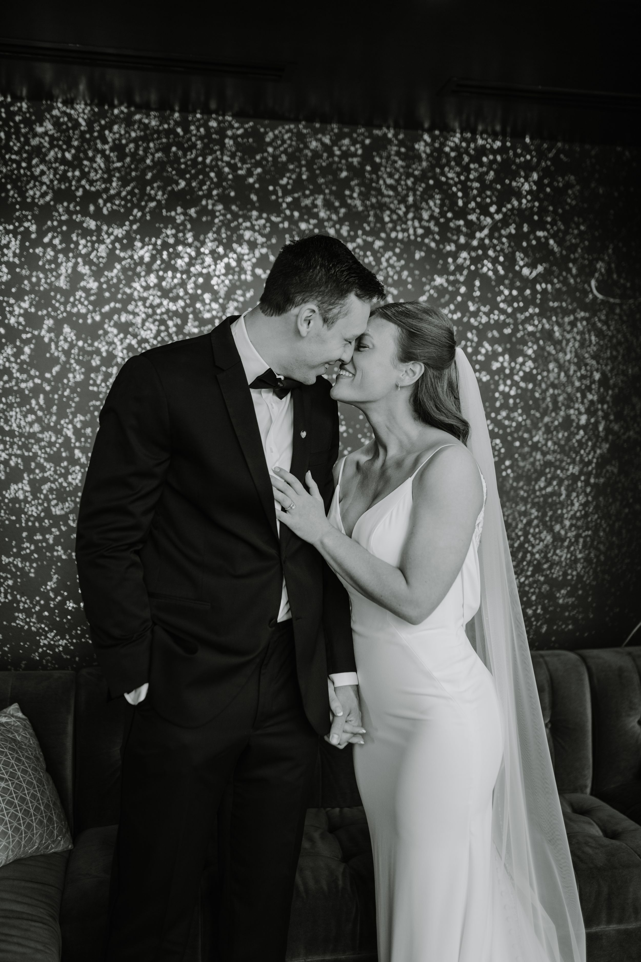 Newlyweds share a romantic moment against a sparkling backdrop.