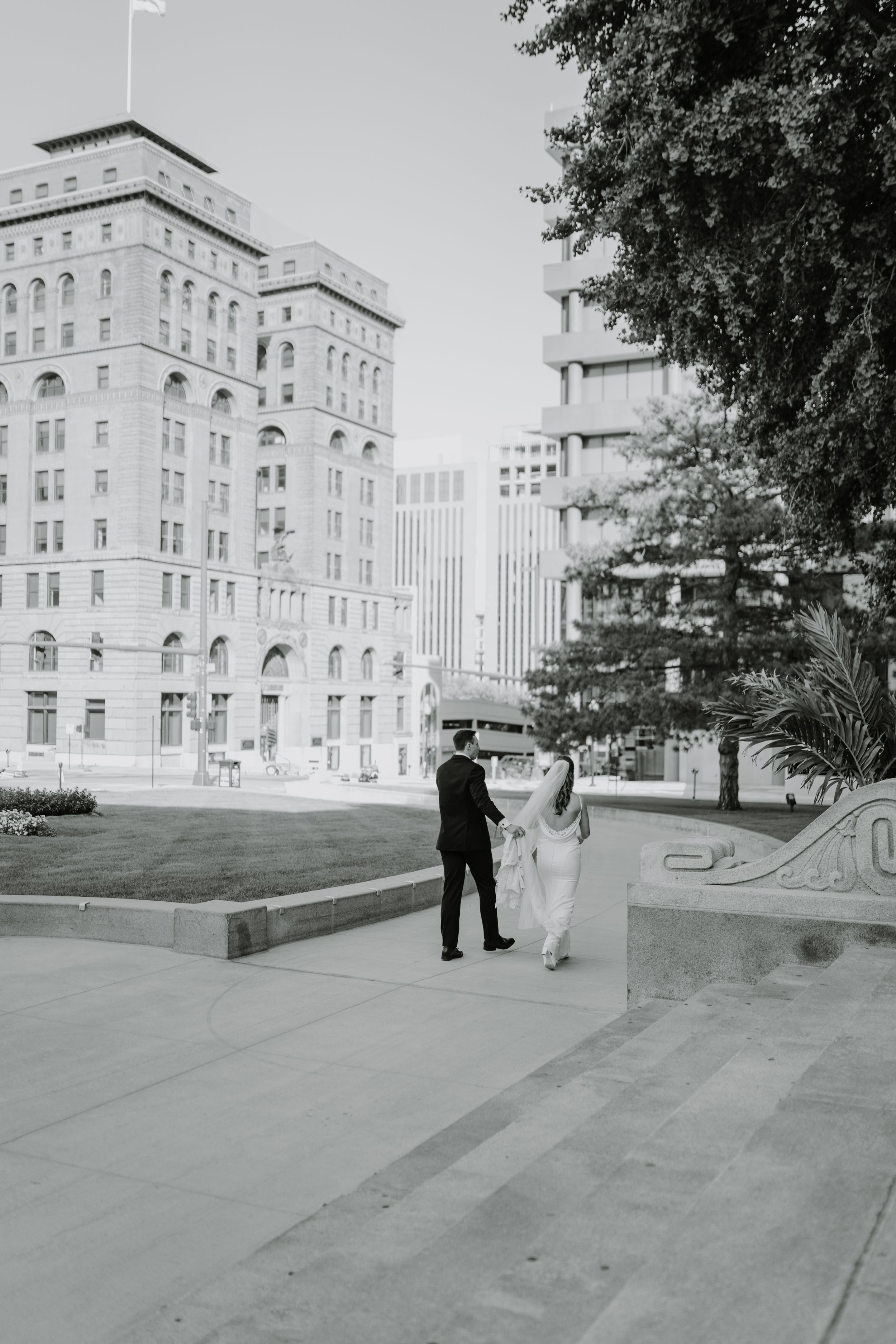 Black and white wedding portrait with urban architecture backdrop.