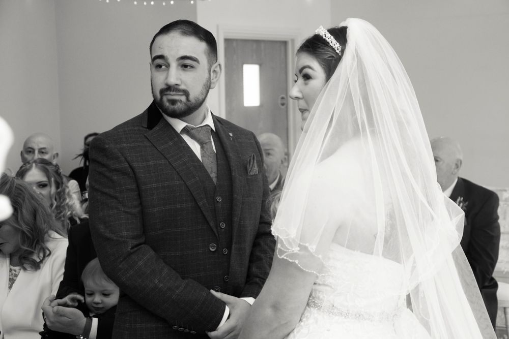A touching black and white moment during a wedding ceremony.