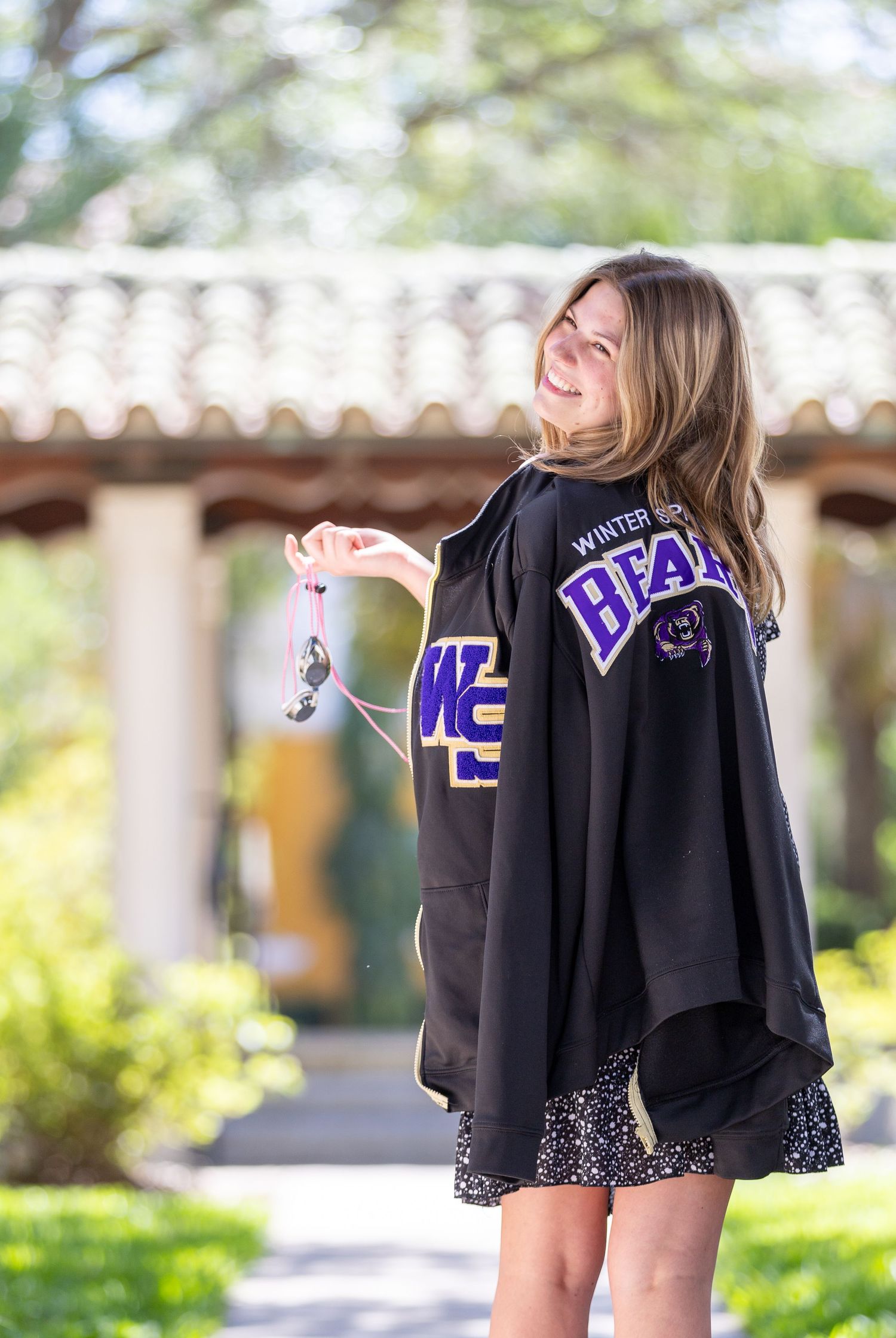 Student wearing purple and black college hoodie poses outdoors on campus. Rollins College, Florida