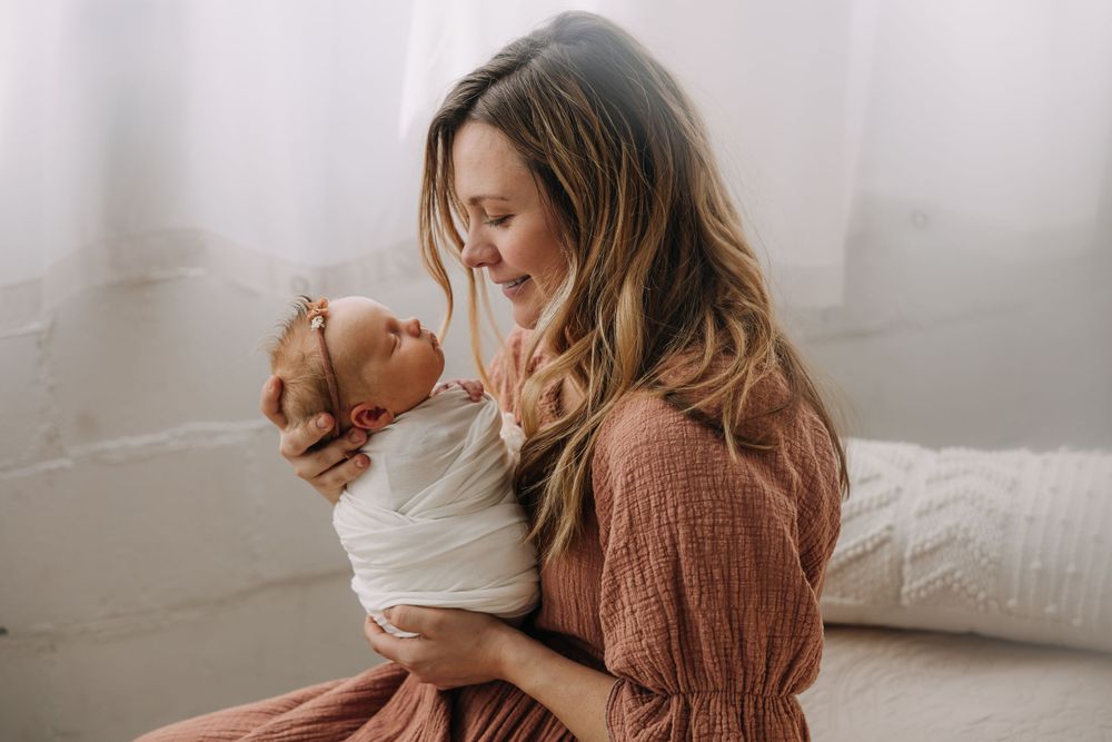 Intimate moment between parent and baby in soft natural lighting.
