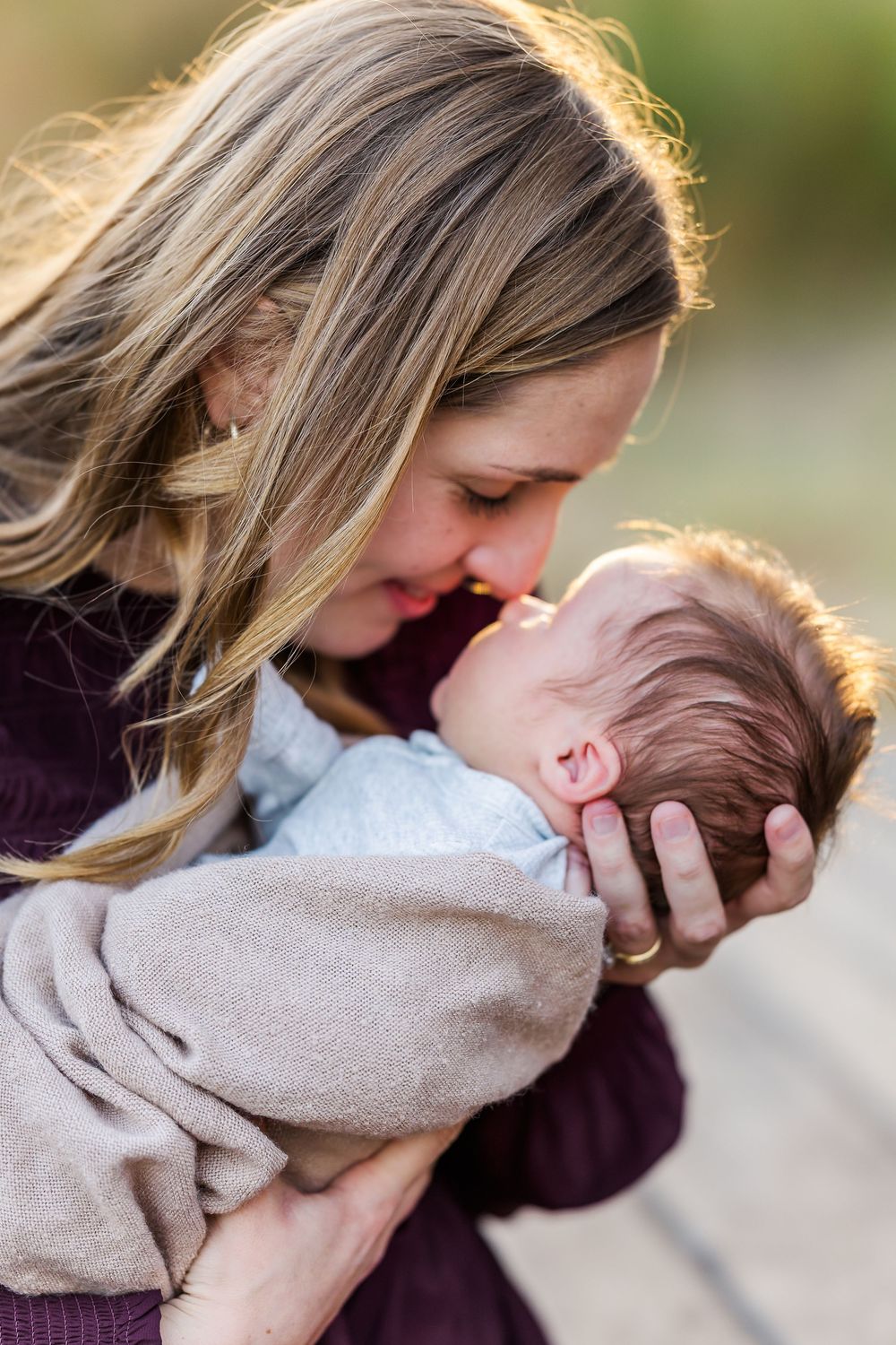 A tender moment captured in a series of photos showing affectionate interaction with a baby in soft lighting outdoors.
