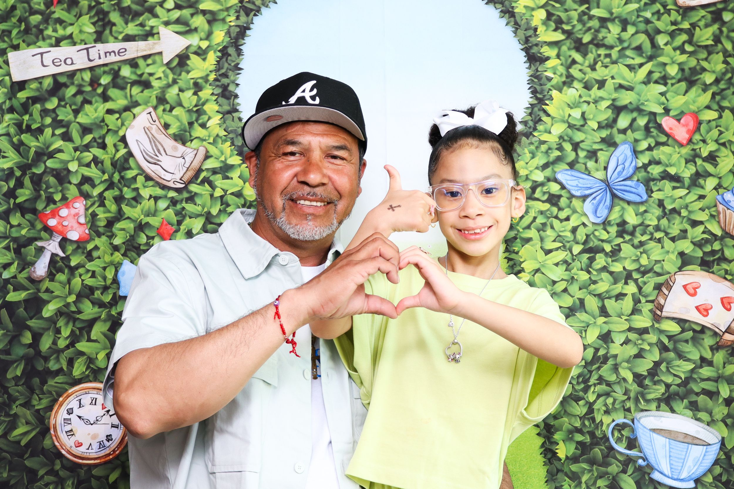 Family photo against decorative garden wall backdrop with butterflies and clock props.