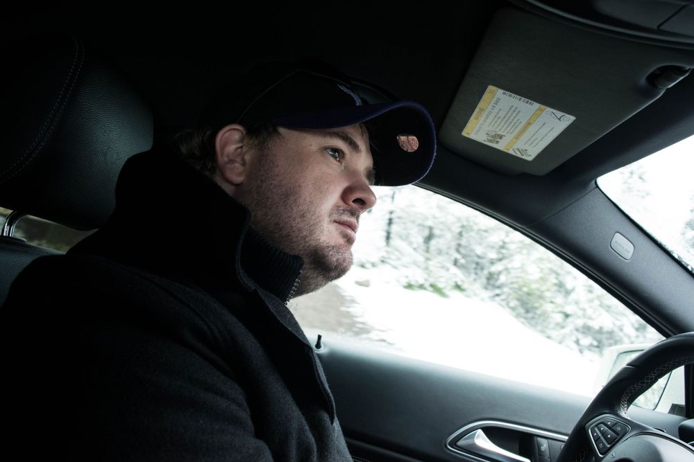 Winter view from inside car showing driver navigating snowy conditions.