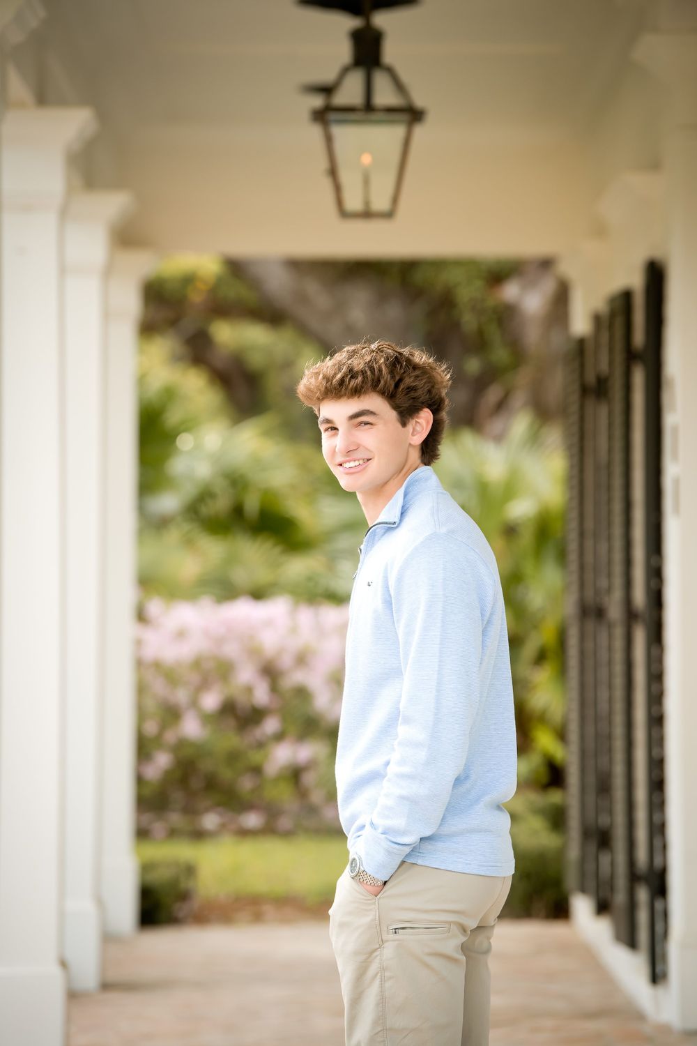Casual portraits taken along a covered walkway with white columns and hanging lanterns.