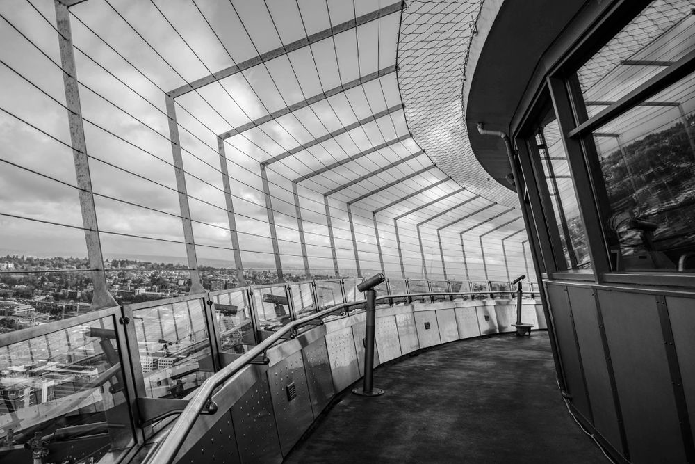 Modern architectural observation deck with curved glass walls and geometric ceiling patterns in black and white.