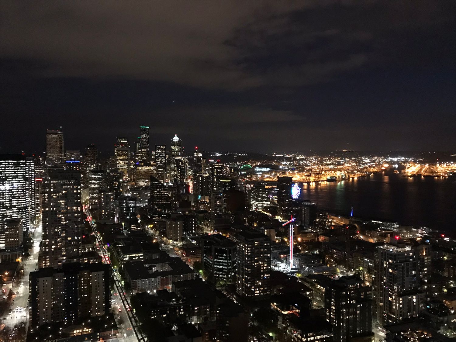 Seattle skyline at night with city lights reflecting off Elliott Bay.