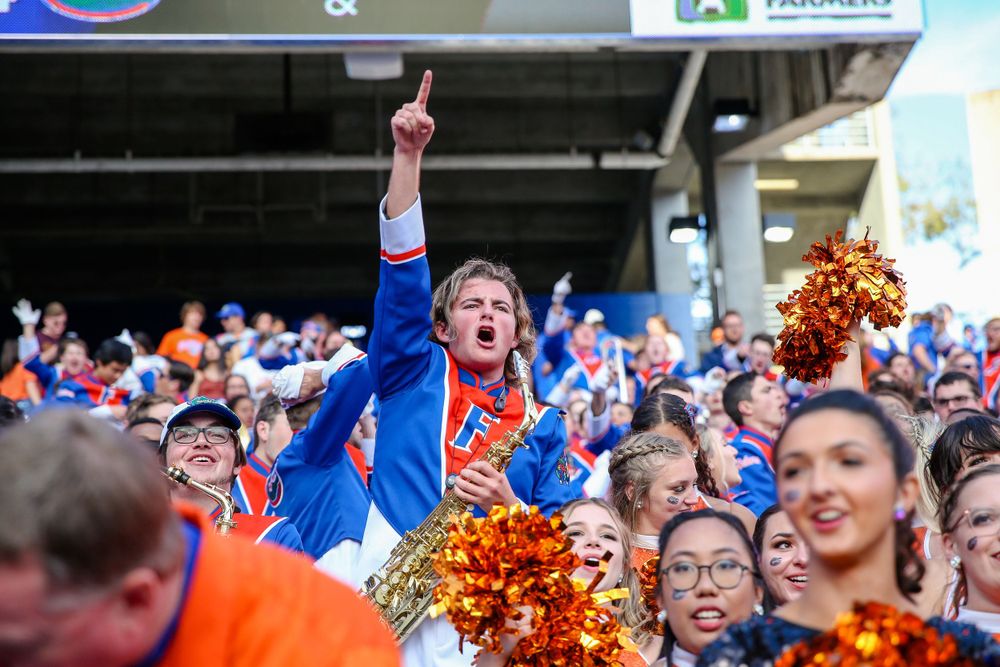 An enthusiastic fan celebrates in the crowd while holding orange and blue pom-poms.