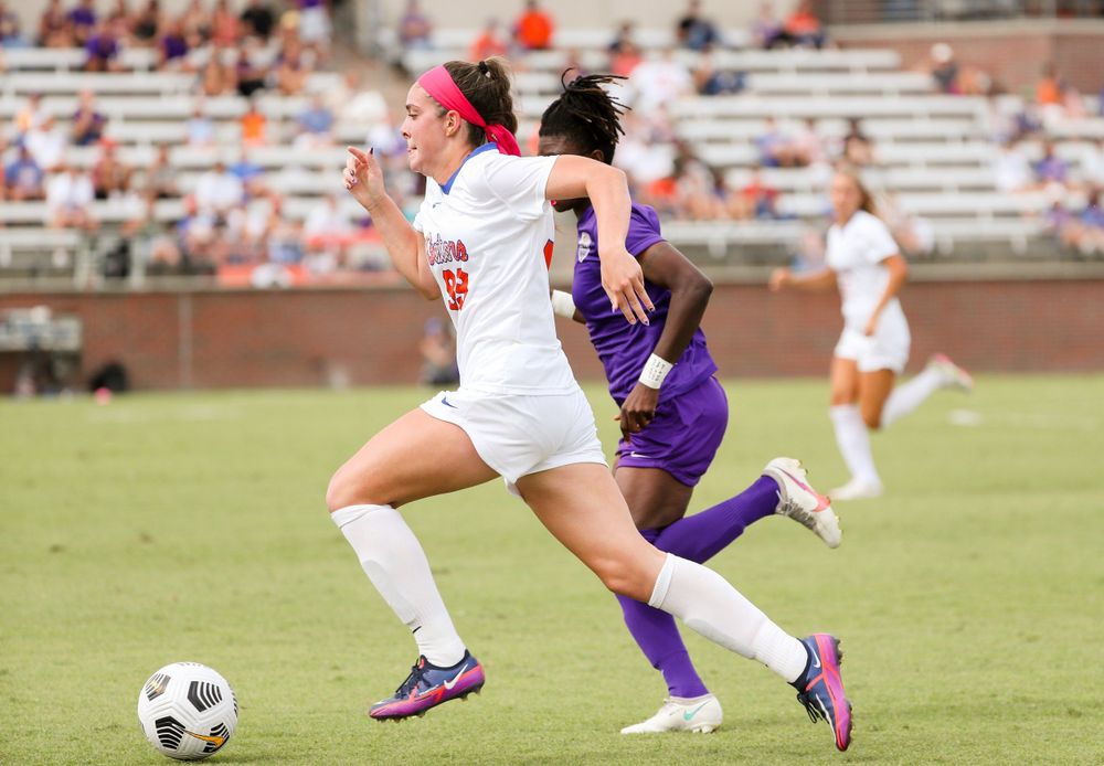 Soccer players compete for ball possession during intense match action.