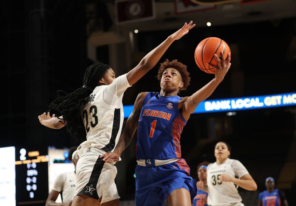 Two basketball players leap for the ball during an intense game moment.