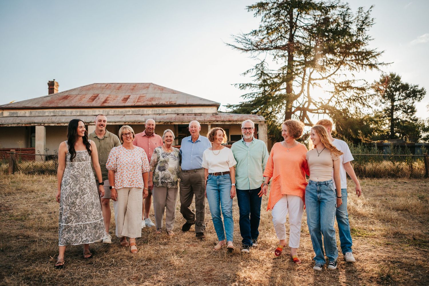 Extended family portrait session outdoors with coordinated outfits at sunset.