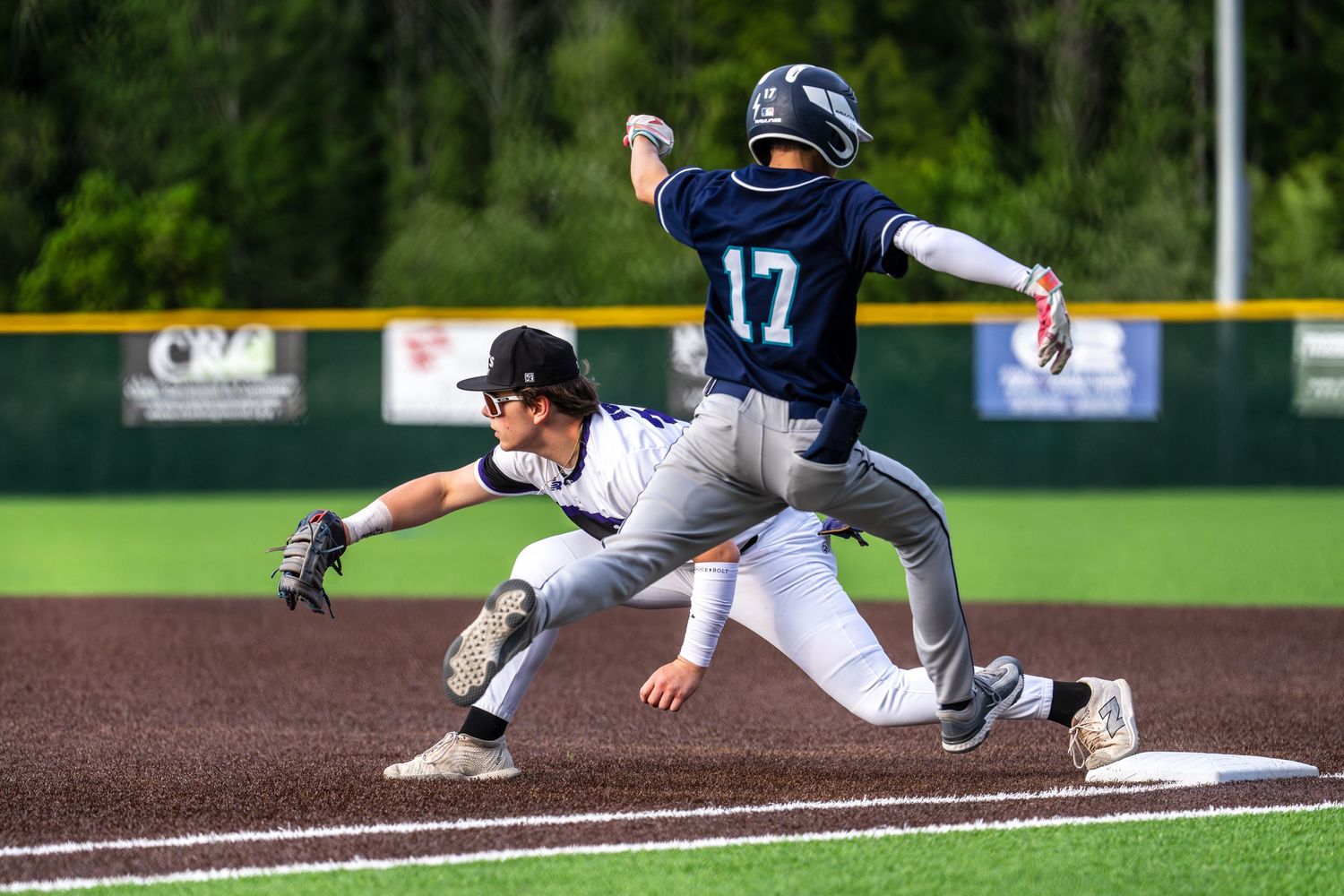 A play at first base where a running is stretches for the bag while the first baseman catches the ball.
