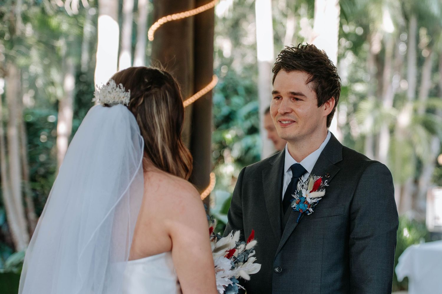 Beautiful wedding ceremony exchange between couple under covered outdoor pavilion.