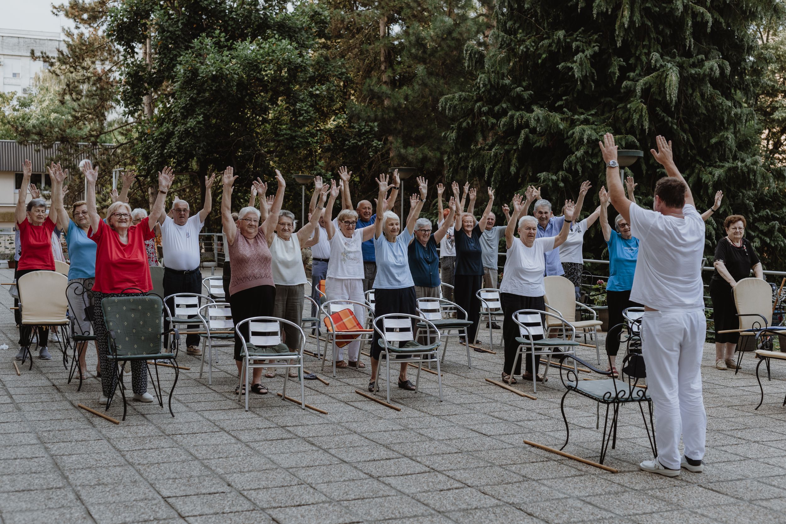 Elderly residents exercising on the terrace of their senior home in Maksimir, captured in brand photography style.