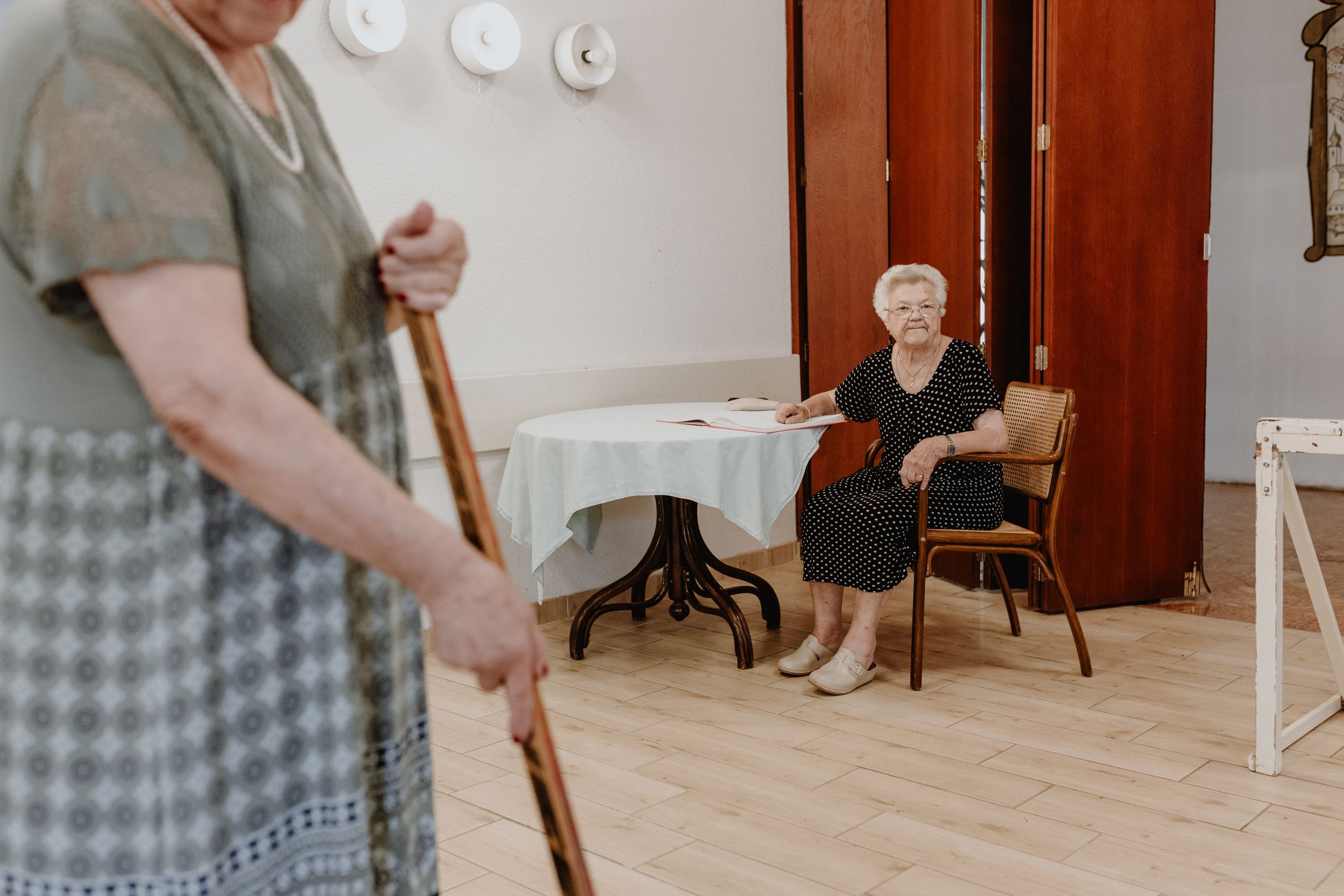 Elderly women enjoying a game inside the senior home, captured in brand photography style.