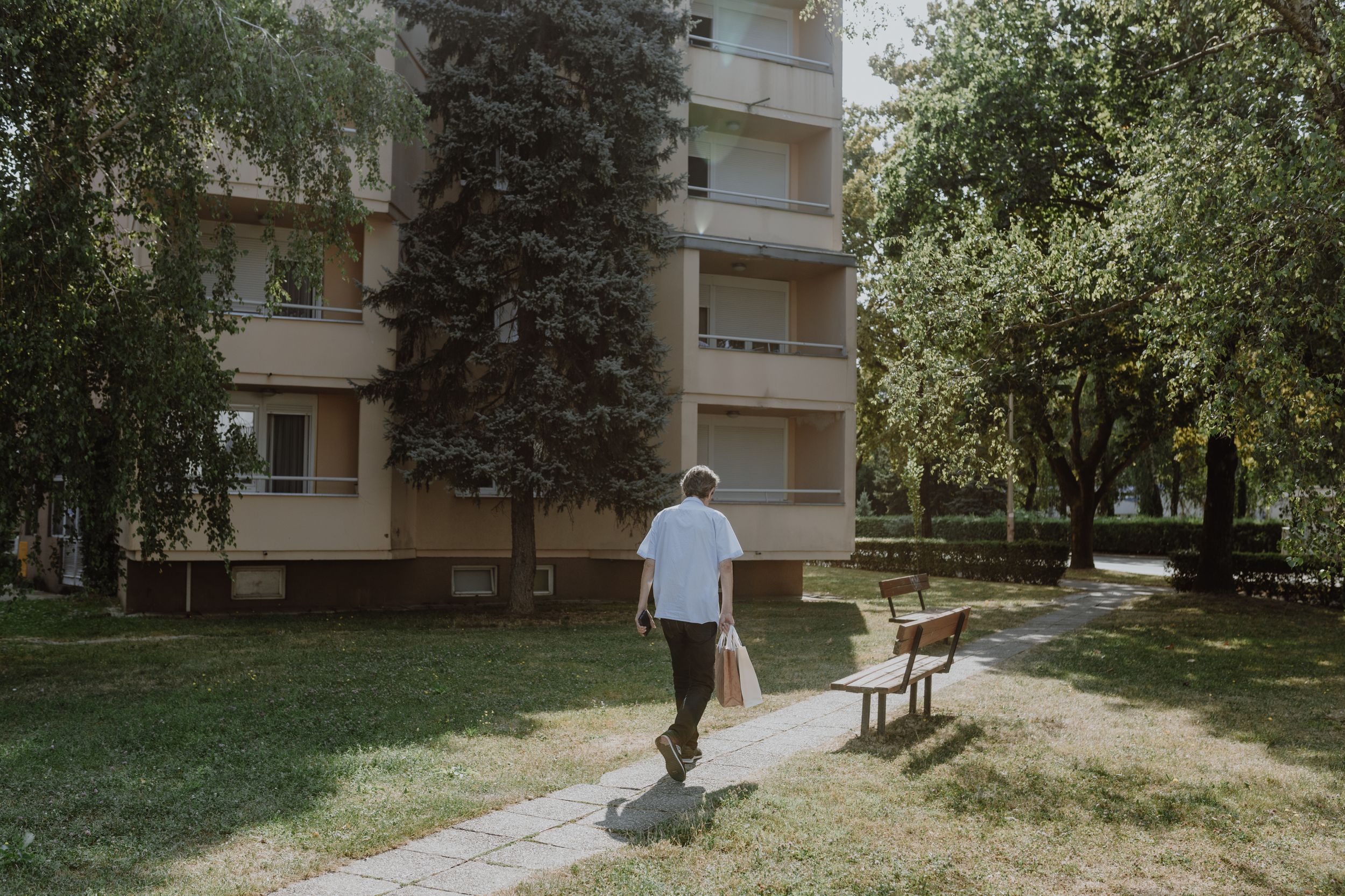 Exterior of a senior living facility in Maksimir with green spaces and walking paths captured in business photography..