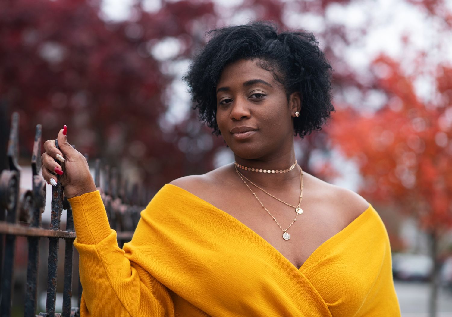 Fall portrait session featuring a yellow sweater against vibrant autumn foliage.