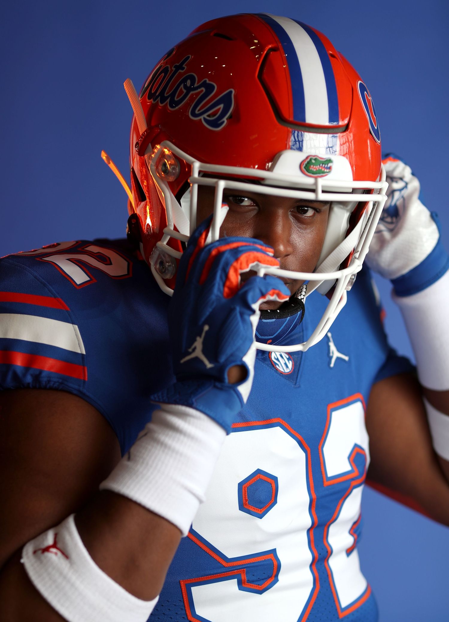 Florida Gators football player in orange and blue uniform wearing number 92 against blue background.