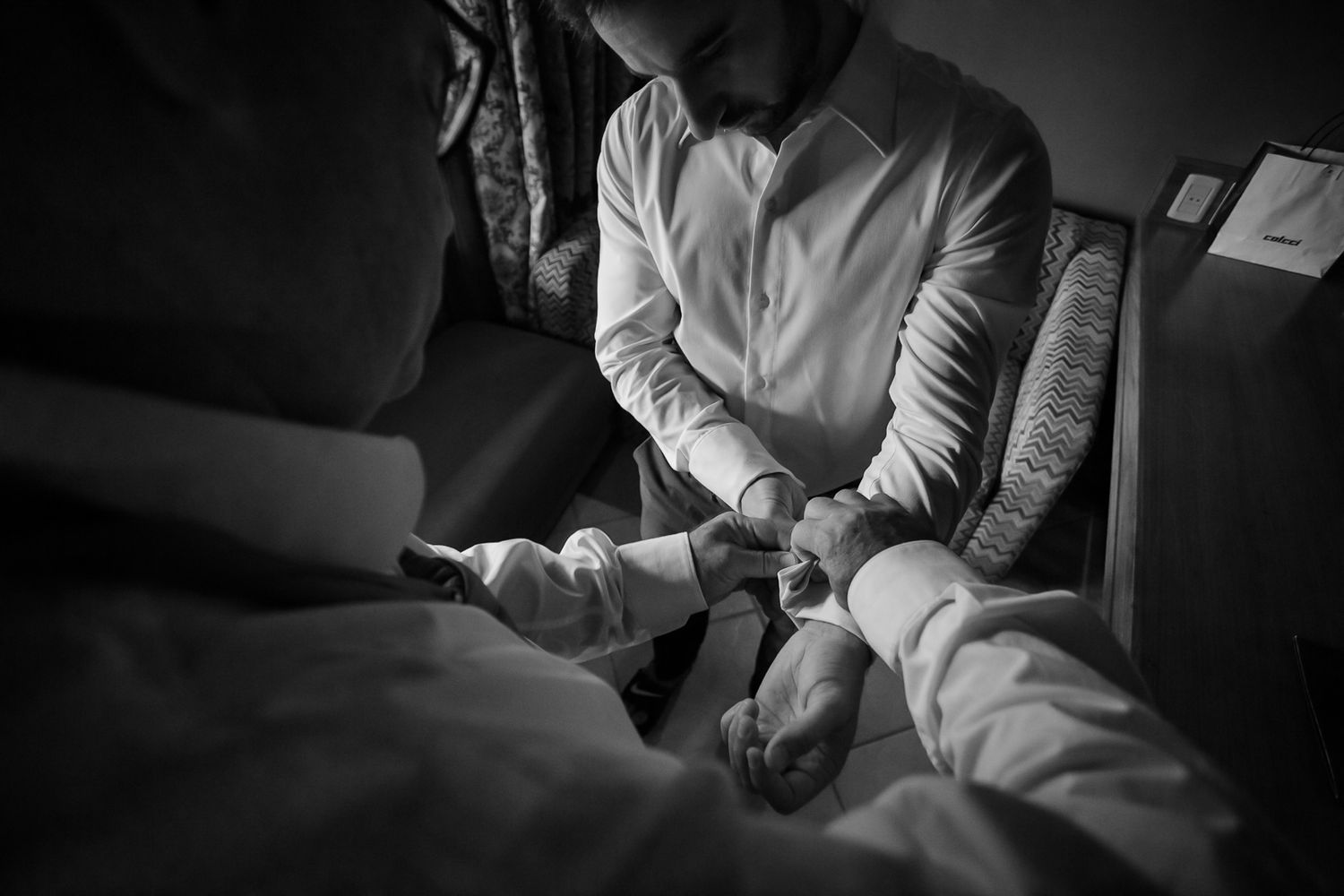 A black and white image showing final preparation moments before a ceremony.
