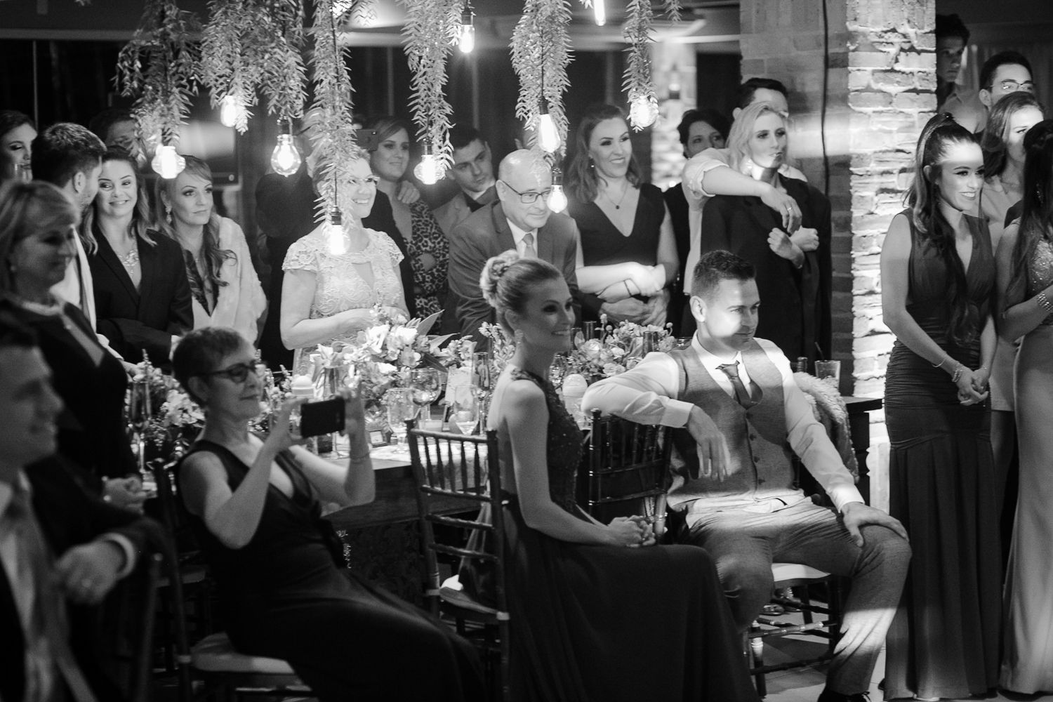 Wedding guests seated at elegantly decorated tables watch the evening's entertainment.