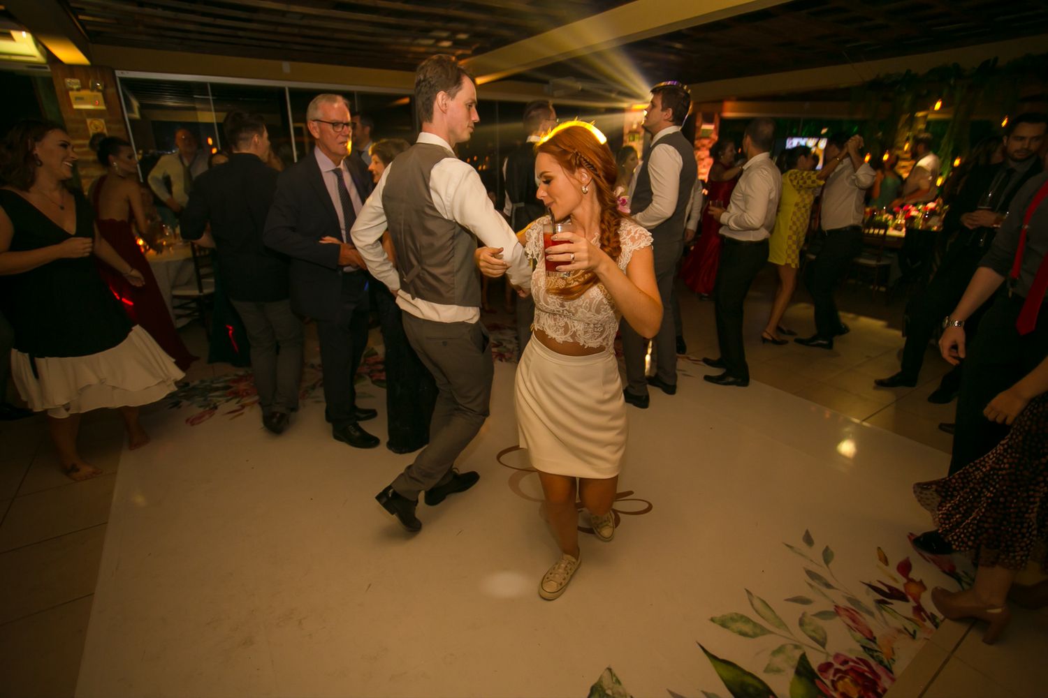Couples dancing on the reception floor under warm ambient lighting.